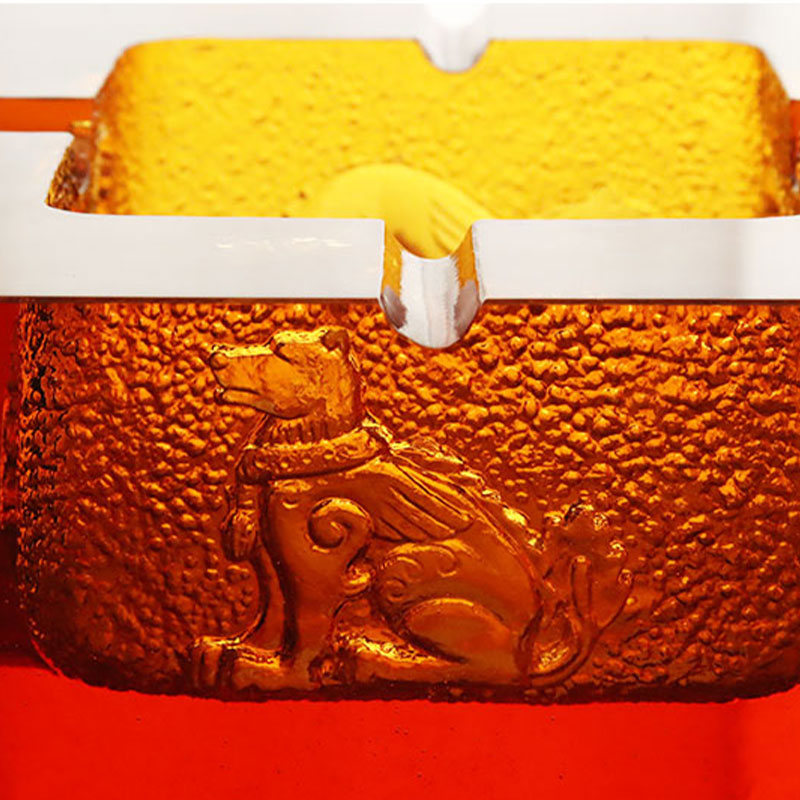 Пепельница из красного стекла с изысканным тиснением животных узоров.