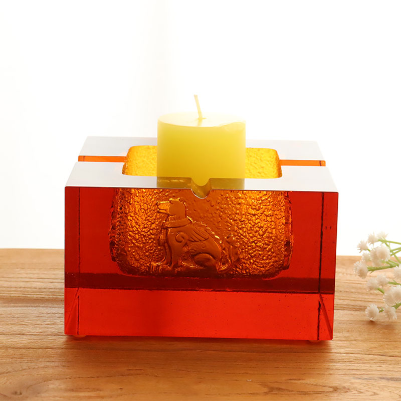 Пепельница из красного стекла с изысканным тиснением животных узоров.