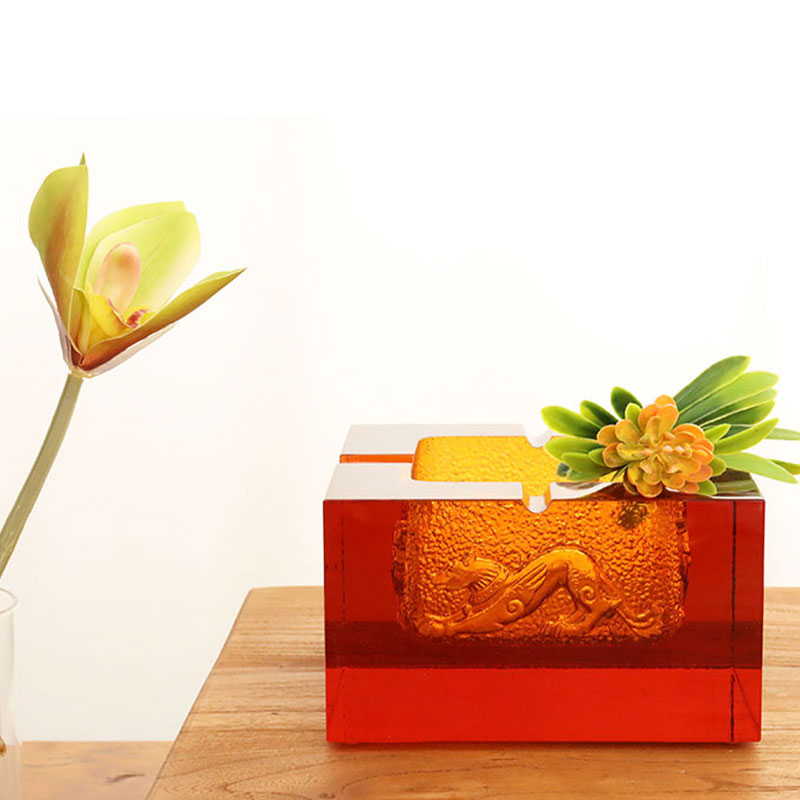 Пепельница из красного стекла с изысканным тиснением животных узоров.