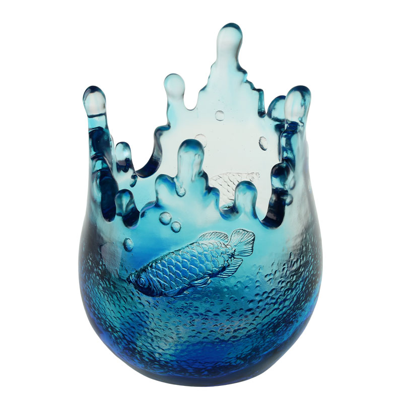 Украшения из синего стекла с выгравированными узорами рыб.